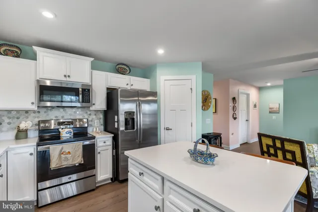 a living room with furniture kitchen view and a large window