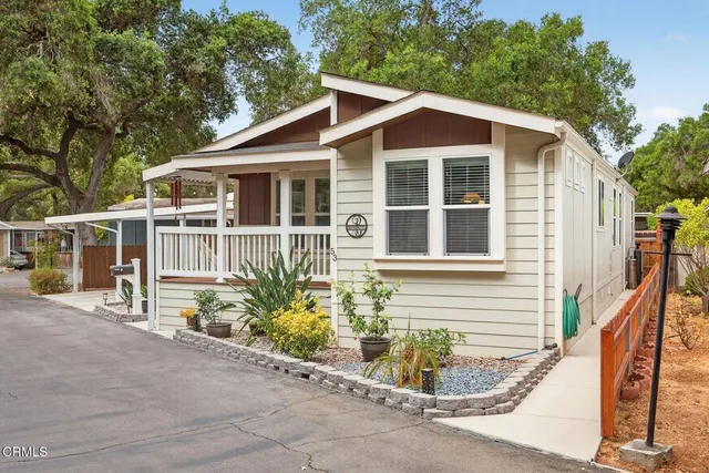 a view of a house with a yard and potted plants