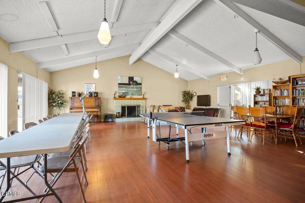 1273 South Rice Road, Unit 53 Ojai, CA 93023 - Photo 32 of 42 a dining room with wooden floor a chandelier a wooden table and chairs