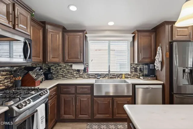 a kitchen with stainless steel appliances granite countertop a stove a sink dishwasher and a refrigerator