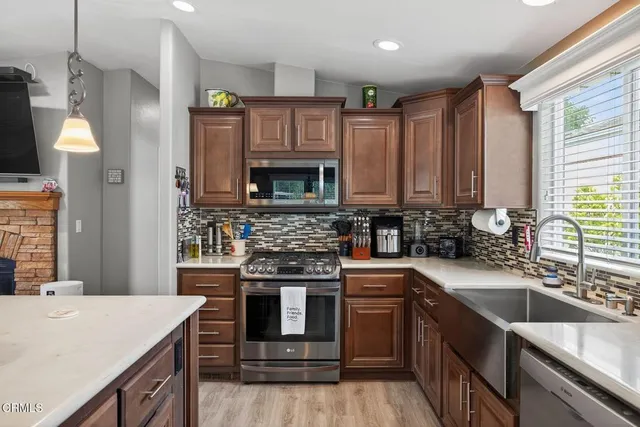a kitchen with stainless steel appliances granite countertop a sink stove and refrigerator
