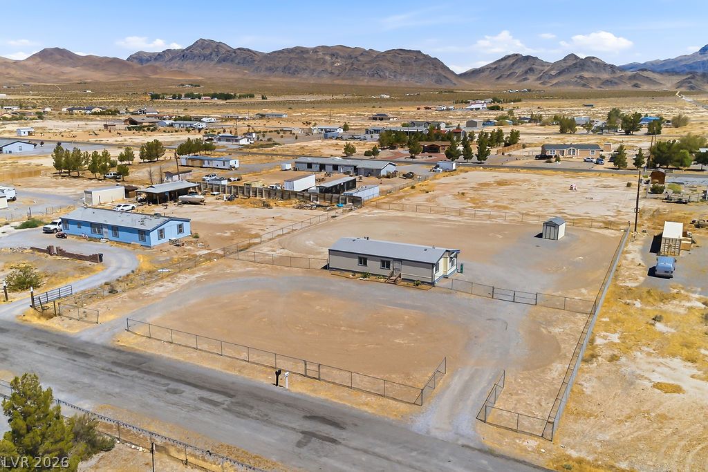4550 Horn Road Pahrump, NV 89048 - Photo 17 of 20 A spacious lot, fenced and ready for development, framed by desert mountains and distant homes.
