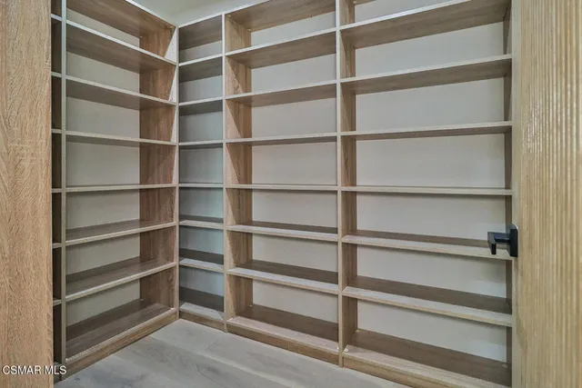 a bedroom with a bed a mirror and a window