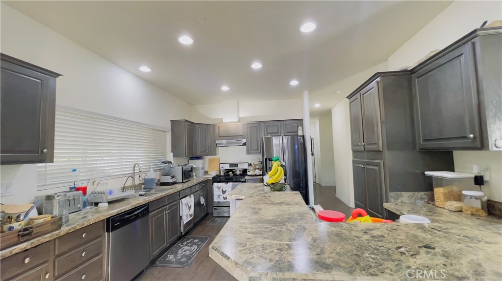 2139 East 4th Street, Unit 142 Ontario, CA 91764 - Photo 12 of 34 a kitchen with stainless steel appliances granite countertop a sink refrigerator and cabinets