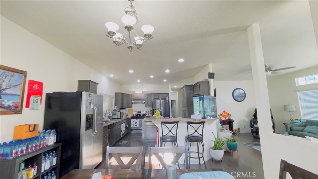 2139 East 4th Street, Unit 142 Ontario, CA 91764 - Photo 14 of 34 a kitchen with stainless steel appliances granite countertop a refrigerator and a dining table