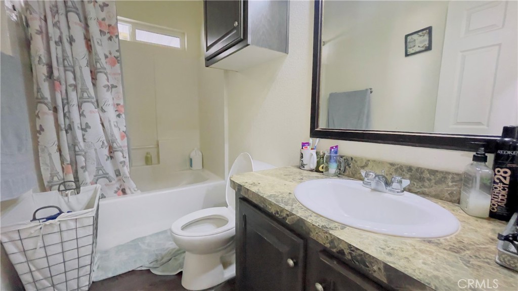 2139 East 4th Street, Unit 142 Ontario, CA 91764 - Photo 20 of 34 a bathroom with a granite countertop sink a toilet a mirror and bathtub