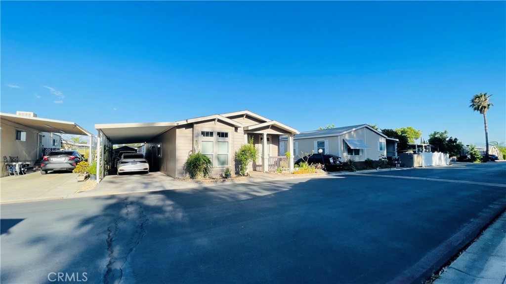 2139 East 4th Street, Unit 142 Ontario, CA 91764 - Photo 4 of 34 a front view of a house with a yard and garage