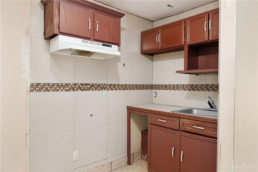 6610 West Mile 2 Road Mission, TX 78574 - Photo 12 of 18 a kitchen with granite countertop cabinets and a wooden floor