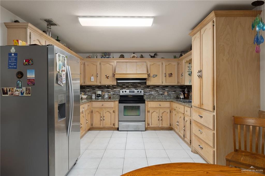6610 West Mile 2 Road Mission, TX 78574 - Photo 6 of 18 a kitchen with stainless steel appliances a refrigerator sink and cabinets