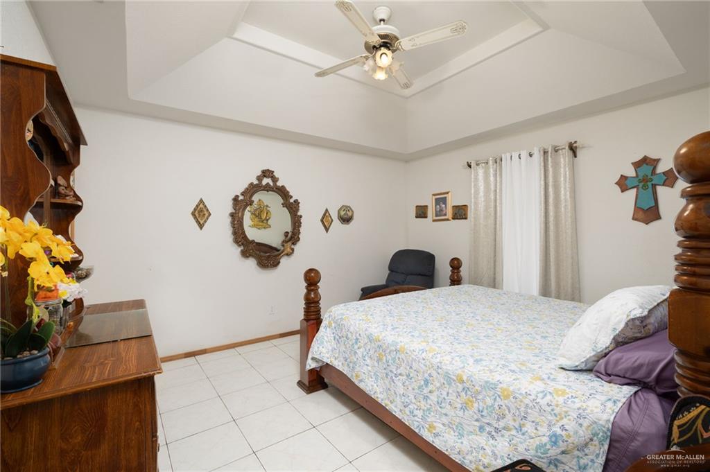 6610 West Mile 2 Road Mission, TX 78574 - Photo 7 of 18 a bedroom with a bed and a chandelier