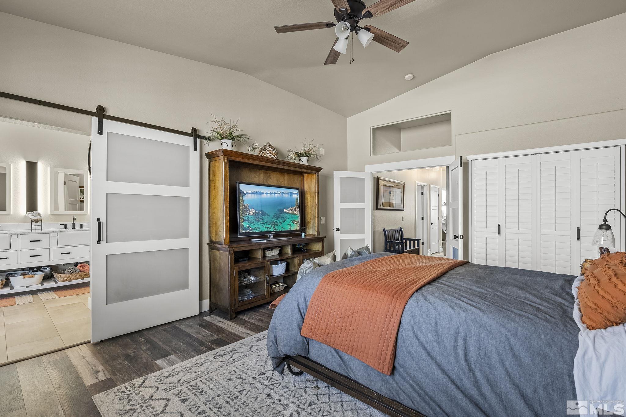 735 Flanders Road Reno, NV 89511 - Photo 21 of 40 a bedroom with a bed and a flat tv screen on wall