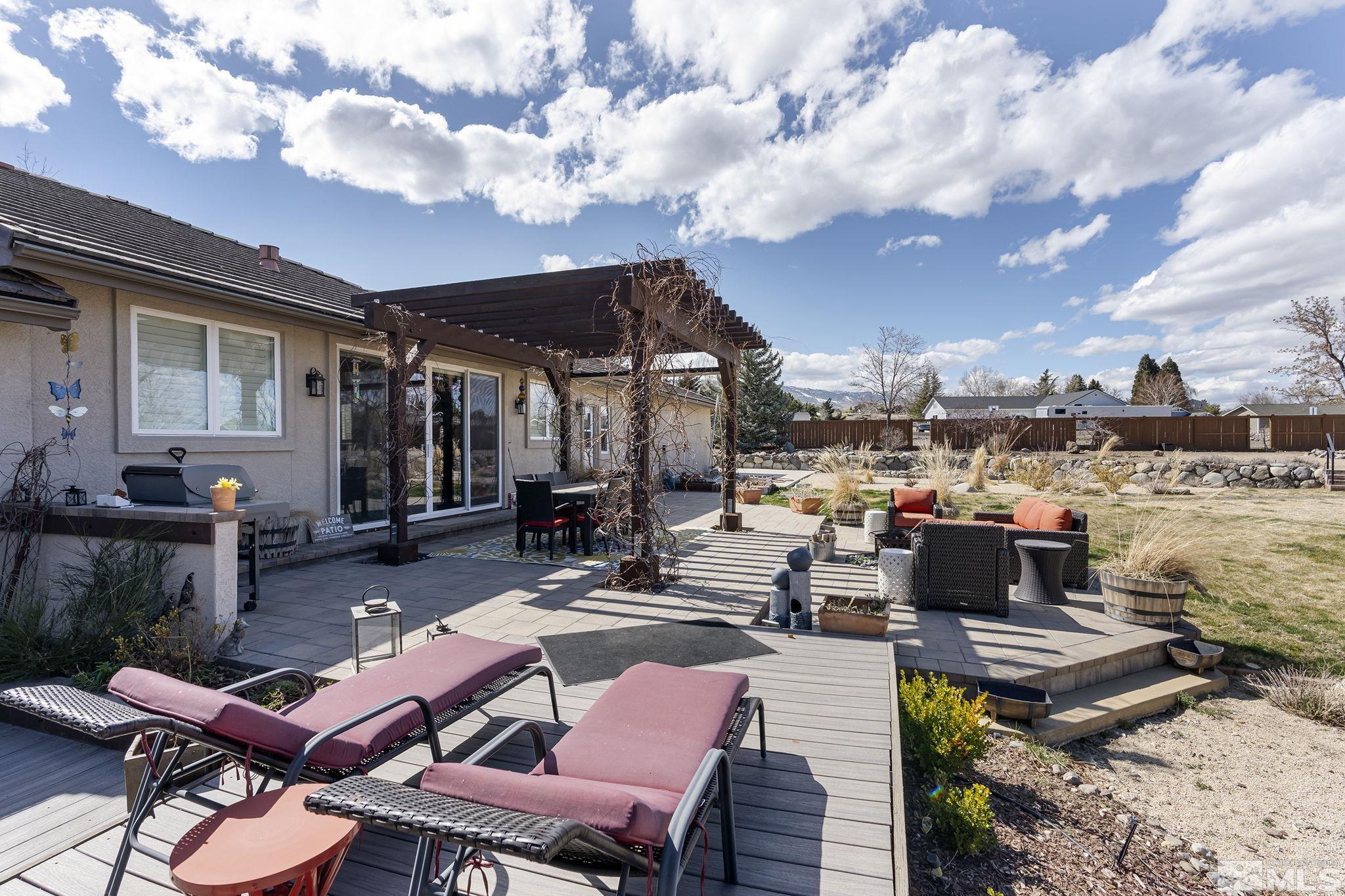 735 Flanders Road Reno, NV 89511 - Photo 34 of 40 a view of a patio with couches table and chairs with wooden floor and fence
