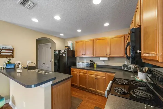 a kitchen with stainless steel appliances granite countertop a sink a stove and a refrigerator