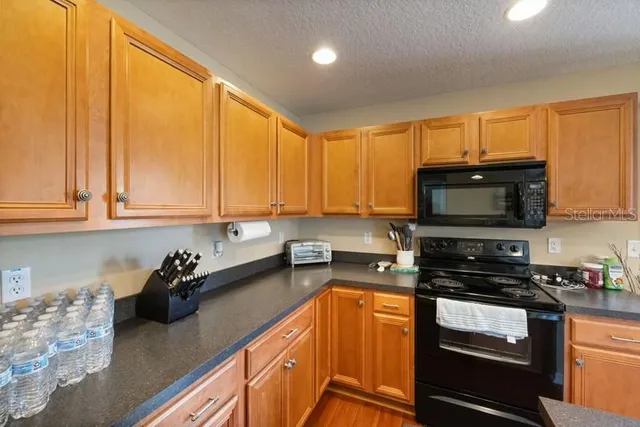 a kitchen with stainless steel appliances granite countertop a stove a sink and a microwave
