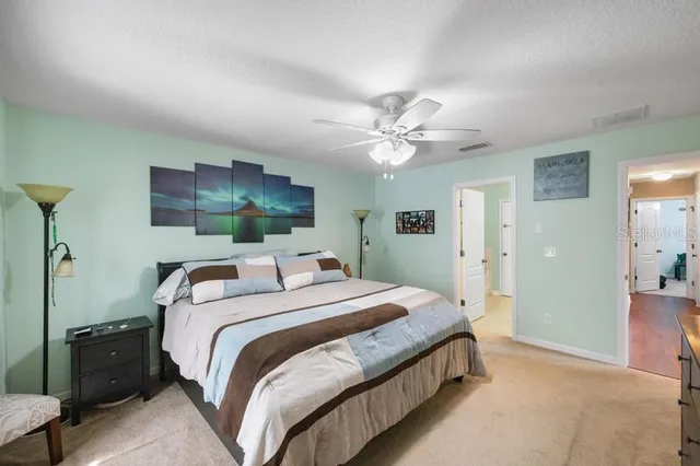 a spacious bedroom with a bed and a chandelier