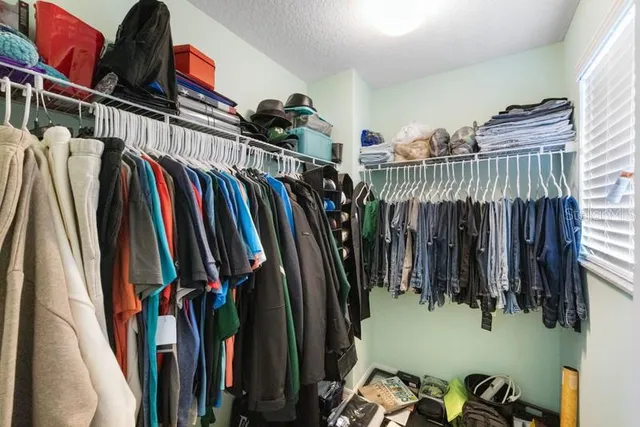 a view of walk in closet with clothes and shoes