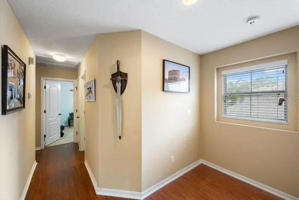 a view of a hallway with wooden floor and closet