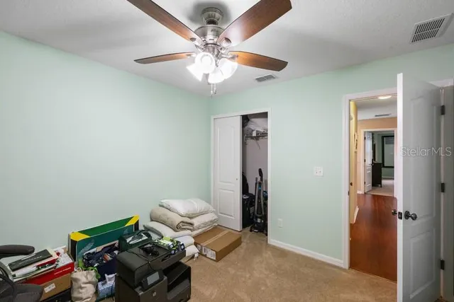 a bedroom with a bed and a chandelier fan