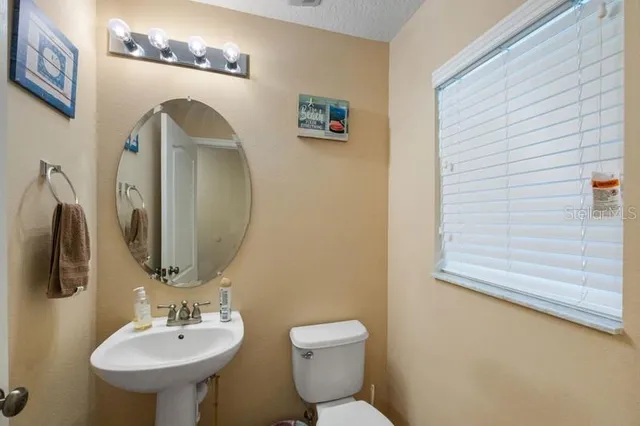a bathroom with a toilet sink and mirror