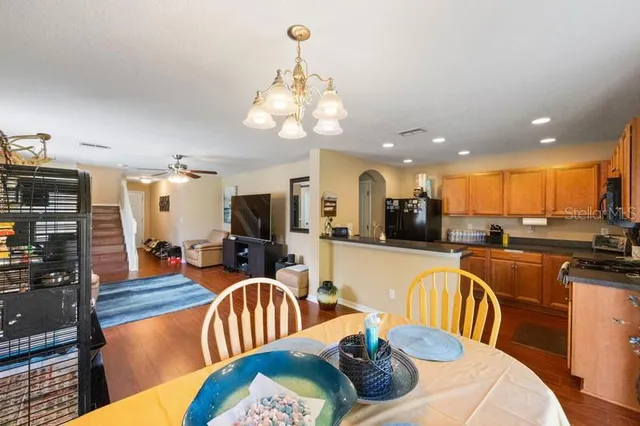 a living room with furniture kitchen view and a large window