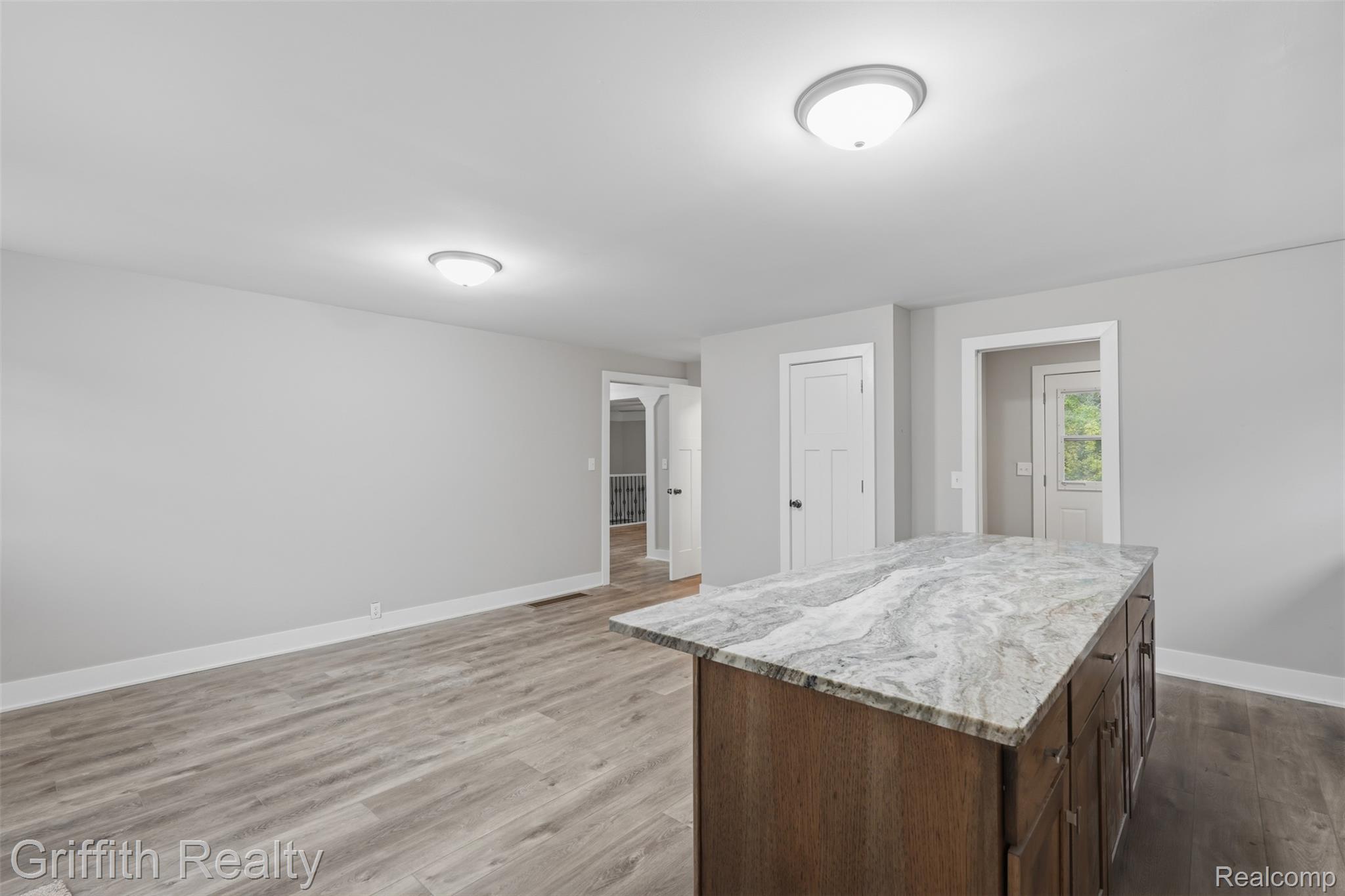 5820 Mack Road Howell, MI 48855 - Photo 12 of 60 Central island with stone countertop, wood-finish cabinetry, and contemporary hardware