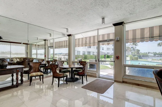 a living room with furniture potted plant and a large window