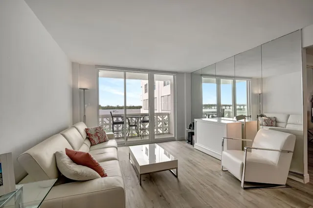 a living room with furniture and floor to ceiling windows