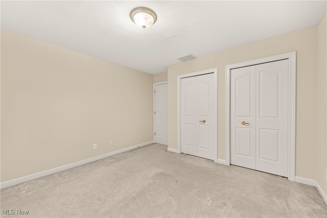 455 Old Reservoir Road Berea, OH 44017 - Photo 41 of 49 Unfurnished bedroom with two closets, a textured ceiling, and light colored carpet