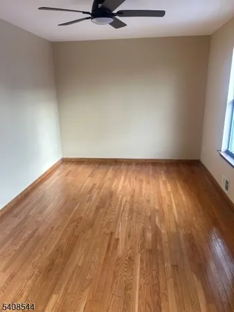 a view of a room with wooden floor and white walls