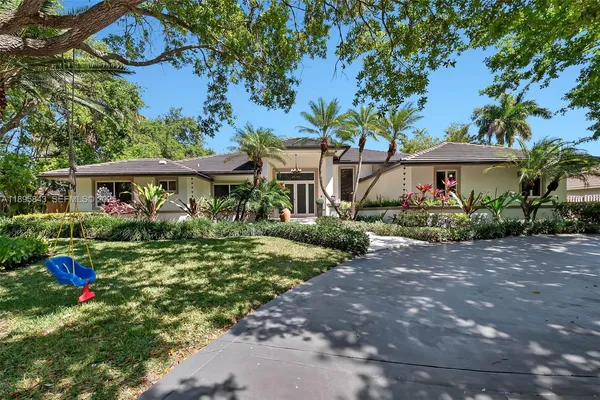 a front view of a house with a yard and potted plants