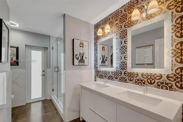 a bathroom with a sink and mirror with toilet
