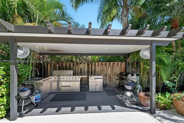 a view of a patio with table and chairs potted plants and palm tree