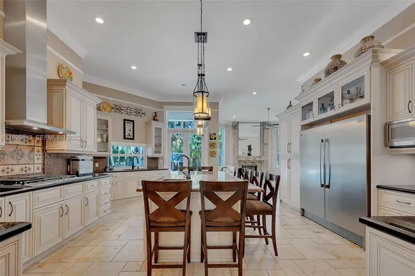 a kitchen with stainless steel appliances kitchen island granite countertop a dining table chairs and granite counter tops