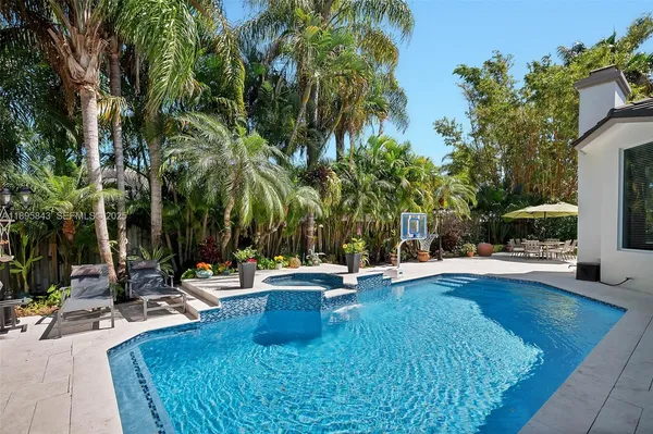 a view of a swimming pool with chairs and a table and chairs
