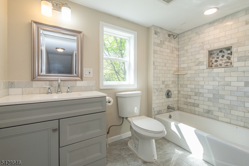 537 Dell Road Mount Arlington, NJ 07850 - Photo 3 of 23 a bathroom with a granite countertop toilet a sink and a bathtub