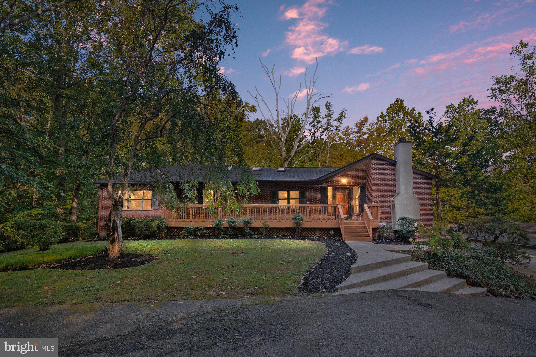 a front view of a house with a yard and trees