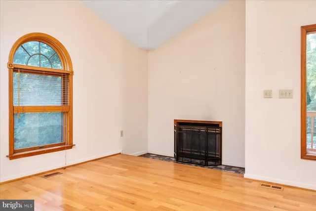 a view of an empty room with a window and kitchen view