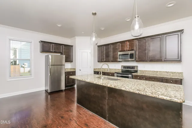 a kitchen with stainless steel appliances granite countertop a refrigerator a stove top oven a sink and dishwasher