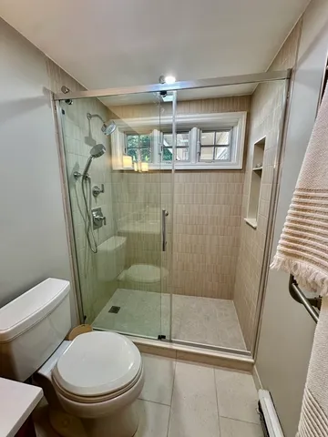 a bathroom with a toilet and a shower