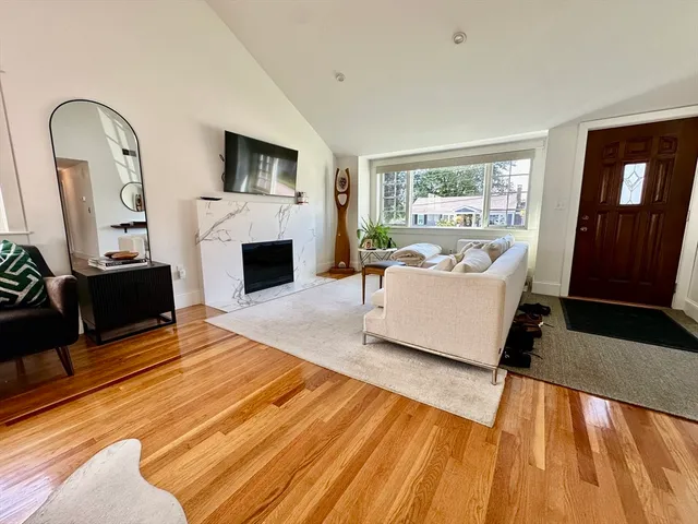 a living room with furniture a fireplace and a floor to ceiling window