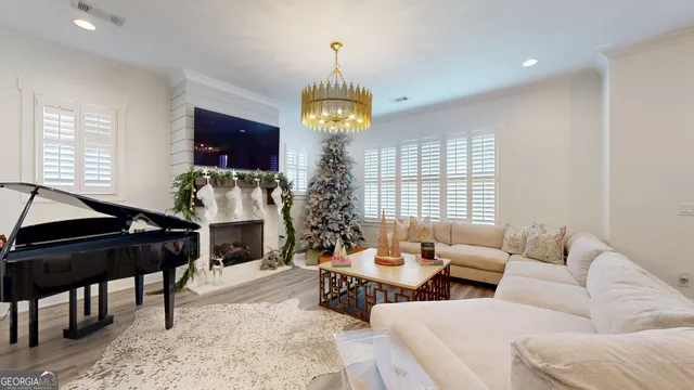 a living room with furniture a chandelier and a rug