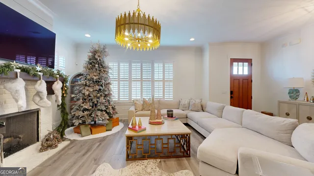 a living room with furniture a chandelier and a large window