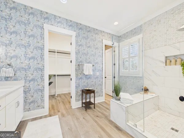 a bathroom with a granite countertop sink a mirror a bathtub and shower