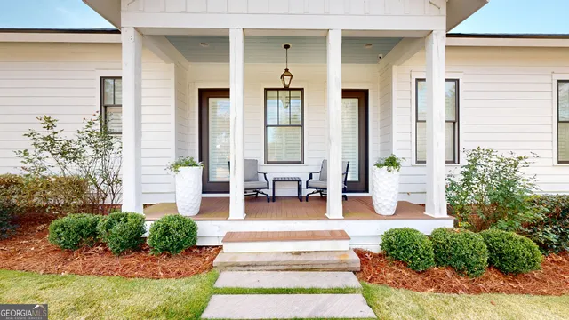 a front view of a house with garden and plants