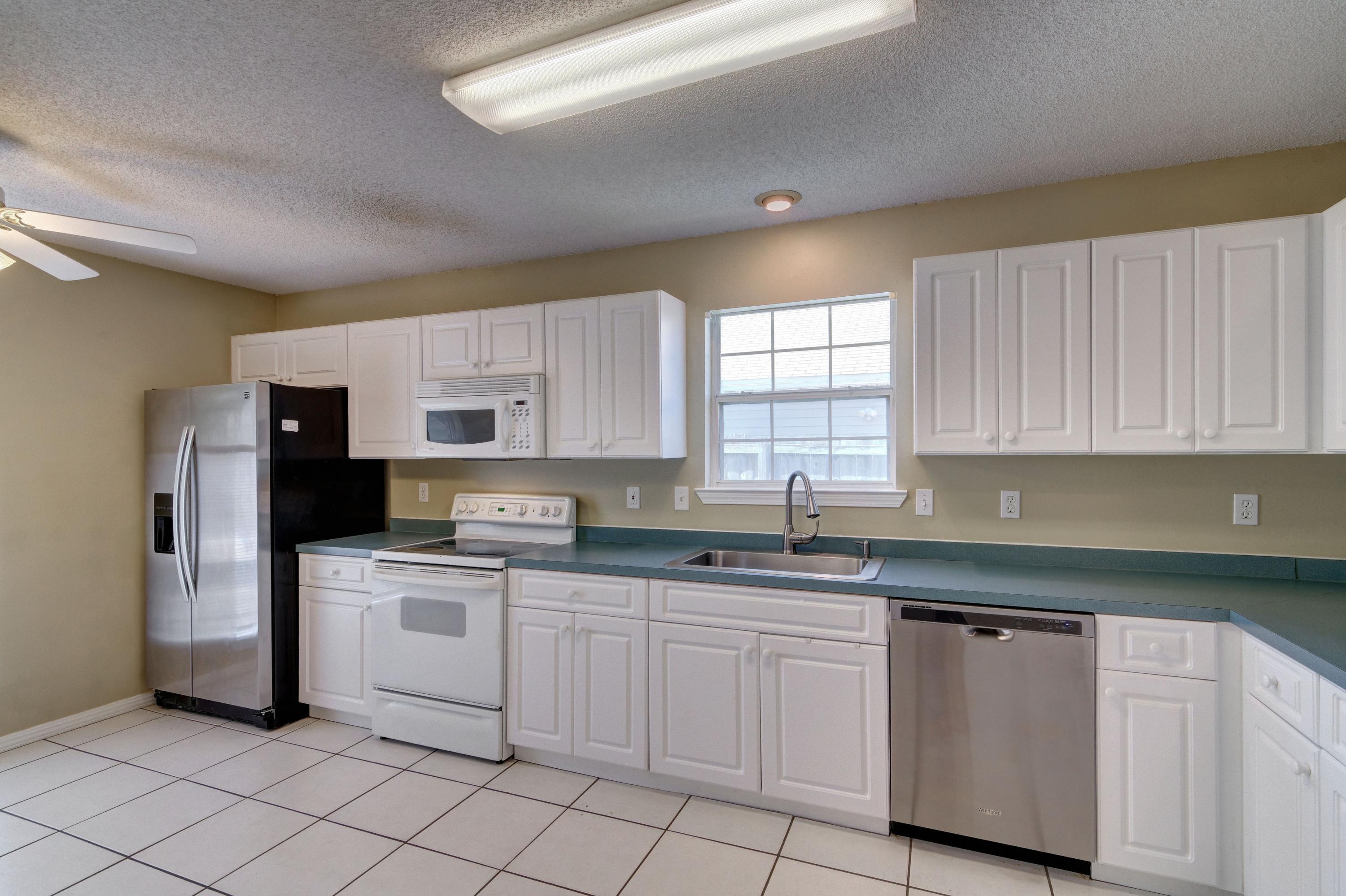 1774 Old Ranch Road Fort Walton Beach, FL 32547 - Photo 6 of 47 a kitchen with white cabinets sink and white appliances