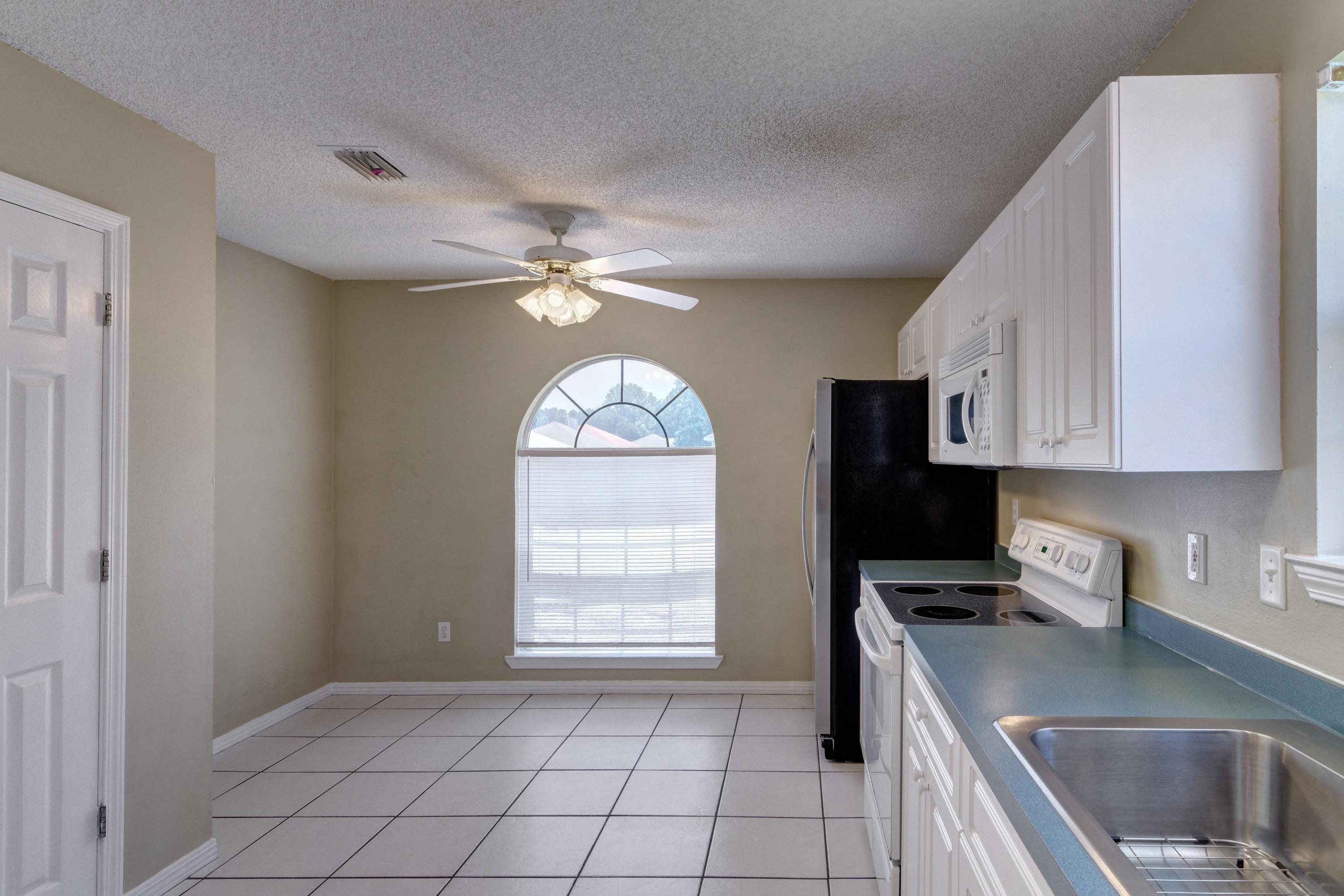 1774 Old Ranch Road Fort Walton Beach, FL 32547 - Photo 7 of 47 a kitchen with a refrigerator a sink and cabinets