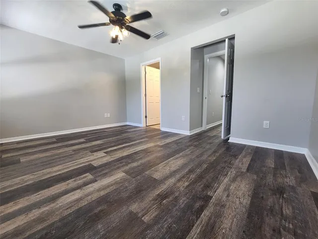 a view of a room with wooden floor and a ceiling fan