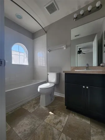 a spacious bathroom with a toilet sink and mirror