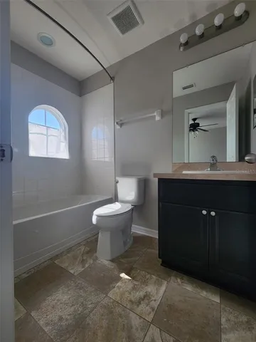 a spacious bathroom with a toilet sink and mirror