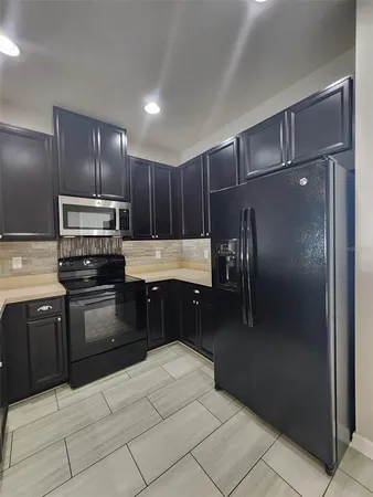 a kitchen with kitchen island granite countertop stainless steel appliances and refrigerator